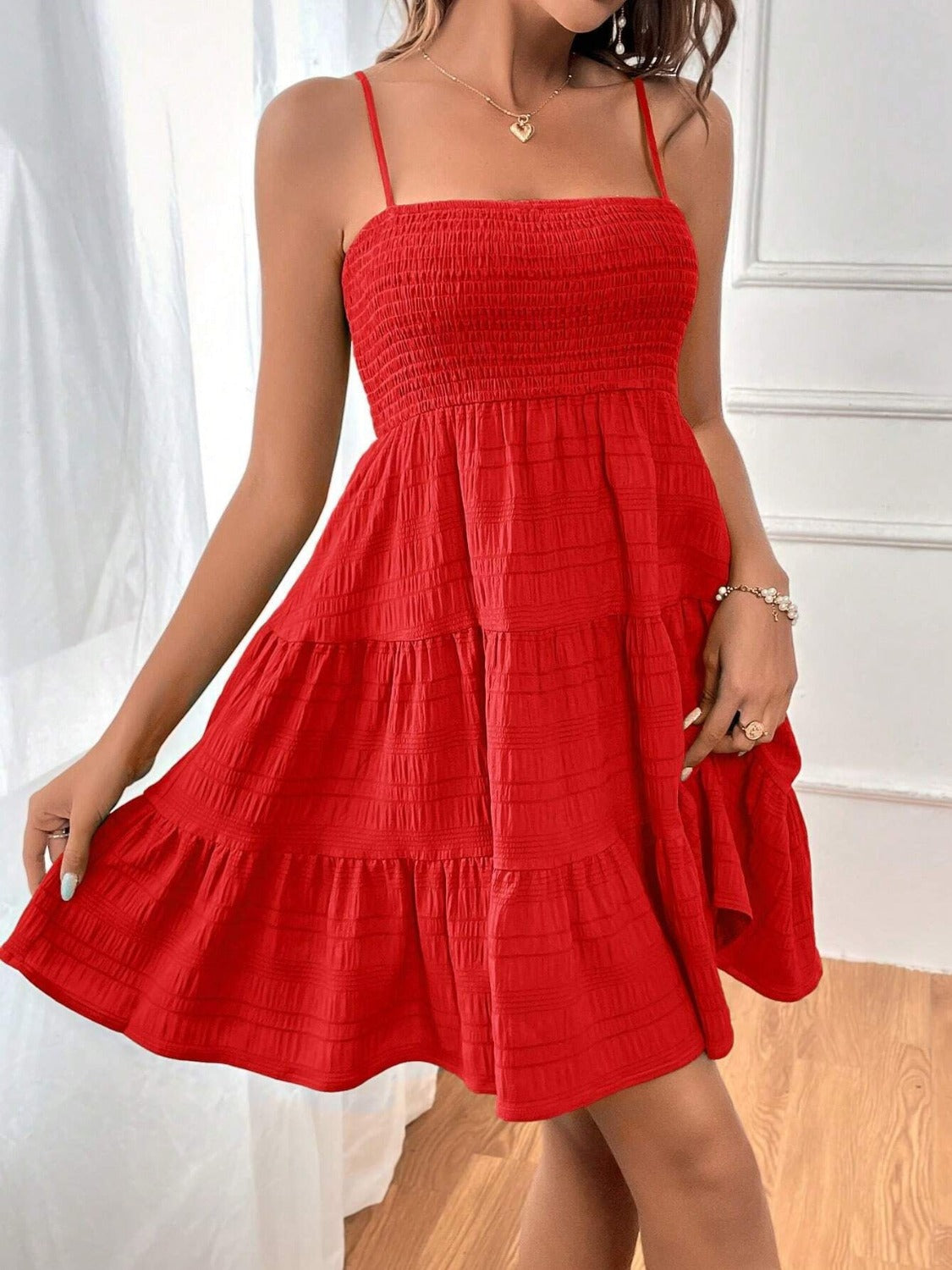 Chic red tiered sundress with a smocked bodice and spaghetti straps, perfect for summer fashion. Elegance meets comfort in this flirty, airy outfit.