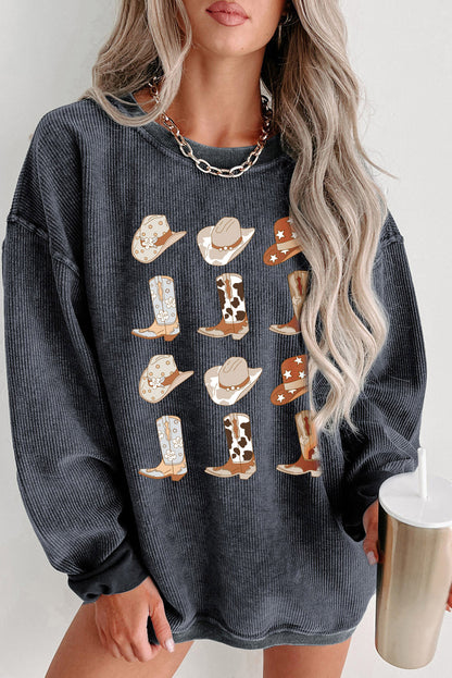 Stylish woman in gray waffle-knit sweater adorned with whimsical cowboy boots and hats pattern, paired with a trendy chunky chain necklace and holding a chic reusable cup. Perfect for a cozy, fashion-forward look.