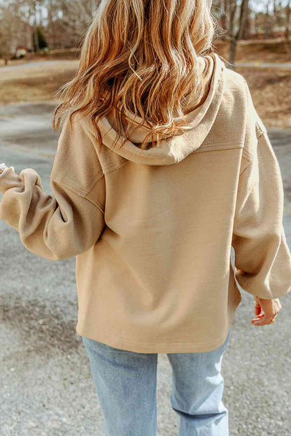 Woman in beige hoodie and blue jeans enjoys a sunny autumn stroll, showcasing casual, comfortable fashion. Ideal for seasonal outdoor activities.