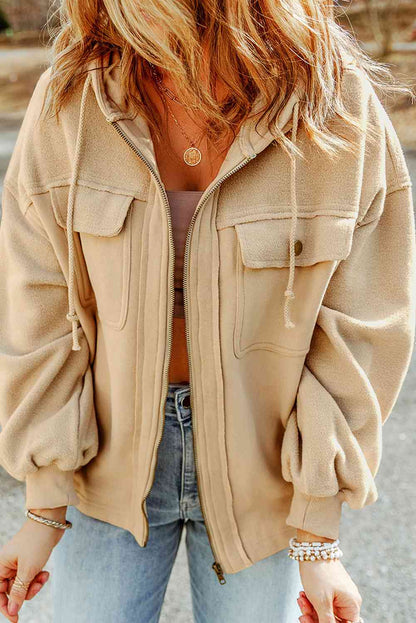 Vintage-inspired beige fleece jacket featuring a zipper closure, flap pockets, and a relaxed fit, paired with a delicate pendant necklace and casual denim. Ideal for a trendy, cozy street style look.