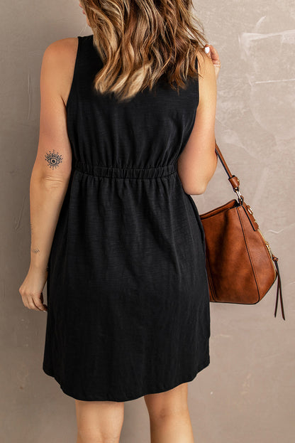 Woman in chic black sundress paired with a stylish brown leather shoulder bag, perfect for summer casuals. Visible arm tattoo adds a modern touch. Ideal for fashion and accessory content.