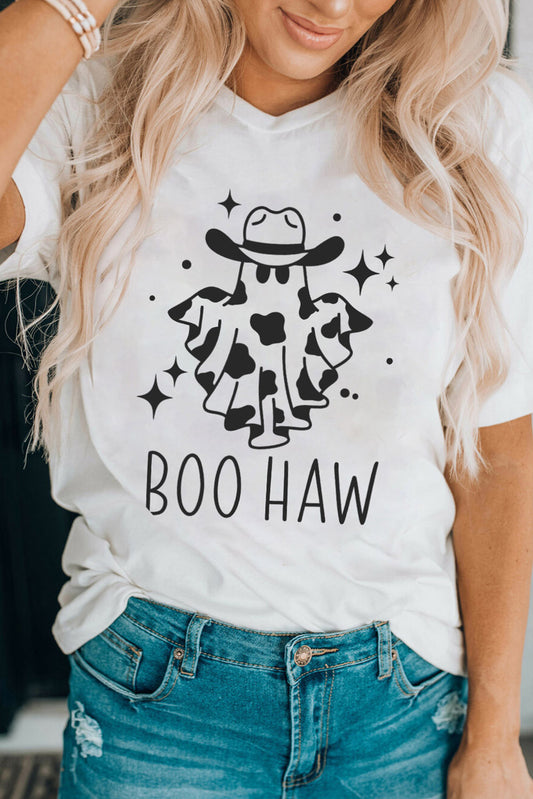 Woman in a white graphic tee featuring a cute ghost in a cowboy hat with "BOO HAW" text, paired with casual blue denim jeans, embodying a playful, festive spirit.