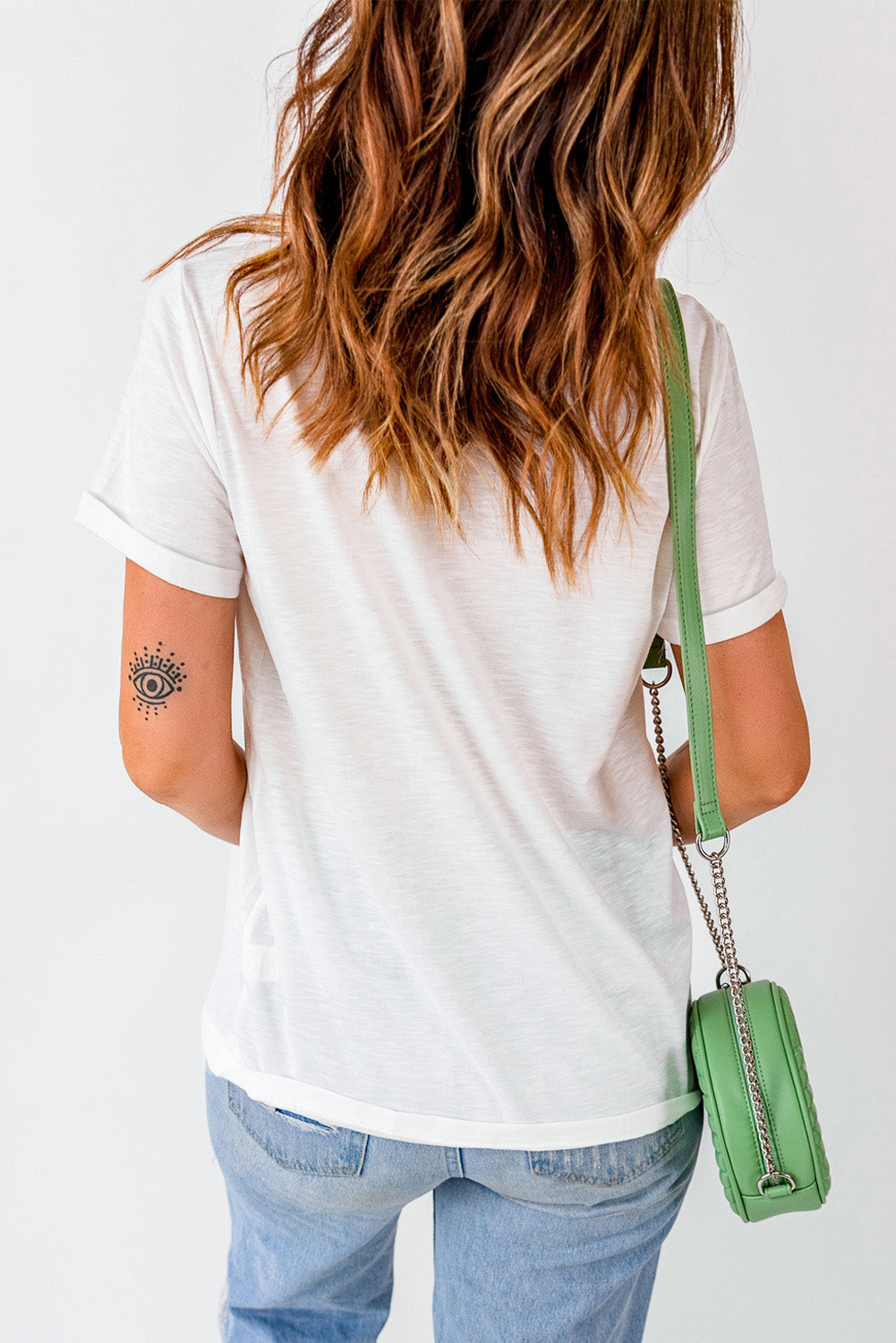 Casual white t-shirt and denim outfit with a pop of color from a trendy mint green crossbody bag, perfect for a chic spring look. #FashionStyle #SpringOutfit #CasualChic