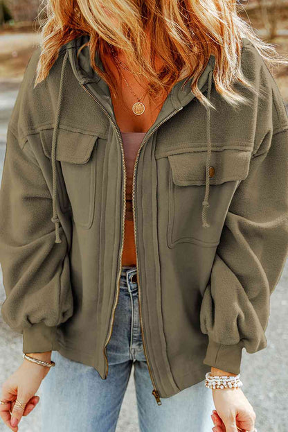 Fashionable woman in a casual olive green jacket, layered necklaces, and denim jeans, exemplifying a chic, laid-back style perfect for fall. Ideal for trendy autumn wardrobe inspirations.