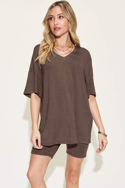 Elegant woman modeling a brown oversized t-shirt with matching shorts, a casual yet chic summer outfit, perfect for everyday fashion. Accessorized with layered necklaces and bracelets to enhance the look.