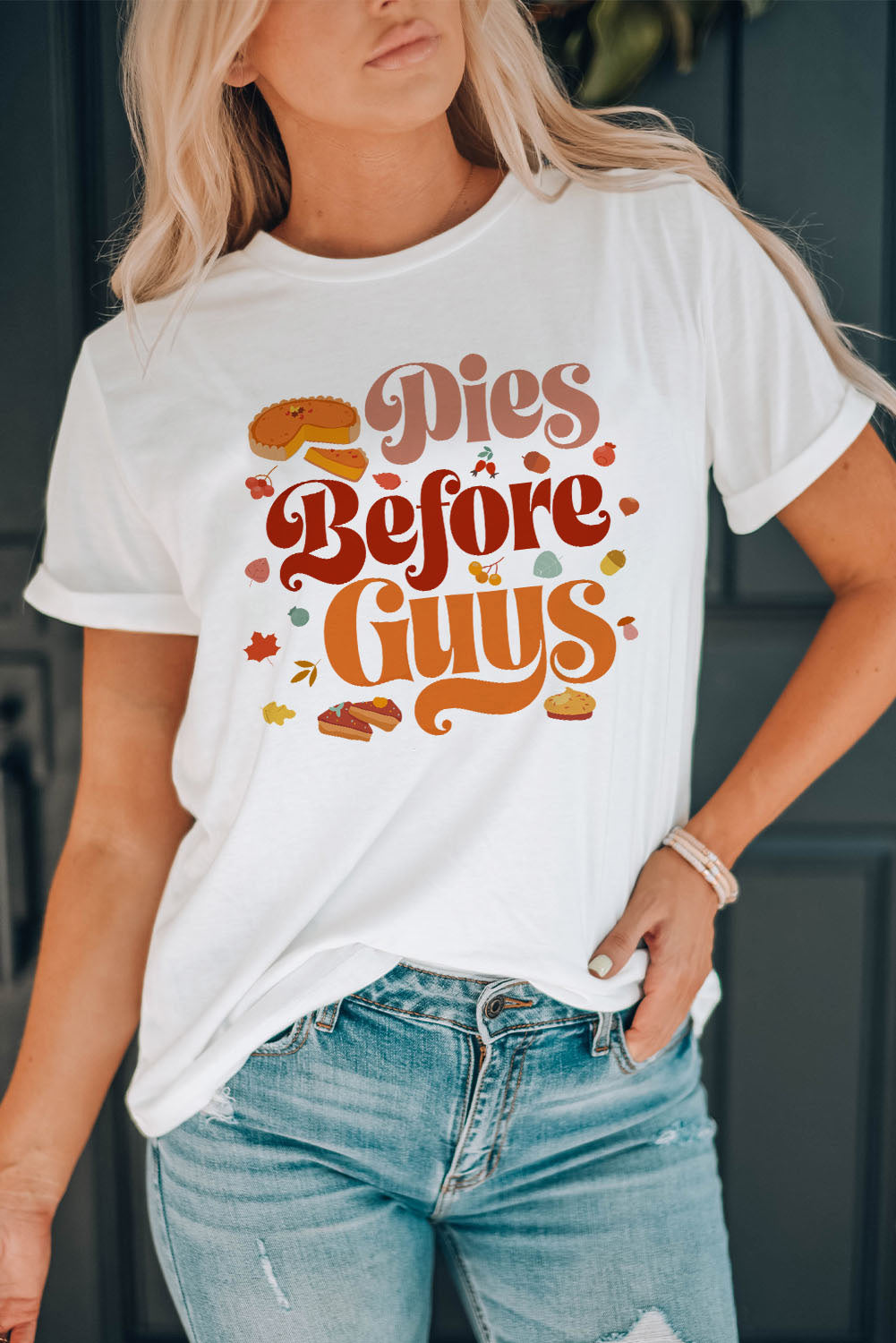 Woman in a white t-shirt with "Pies Before Guys" slogan and pie graphics, paired with blue jeans, for a casual, fun look. #Fashion #CasualStyle #StatementTee